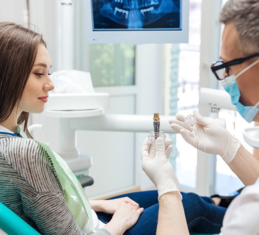 dentist showing a patient how dental implants work in Doylestown 