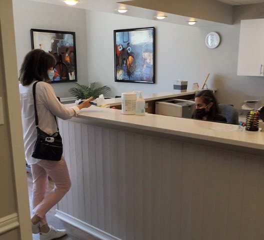 Dental patient checking in at reception desk