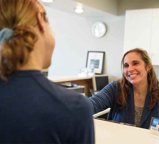 Dental patient checking in at reception desk