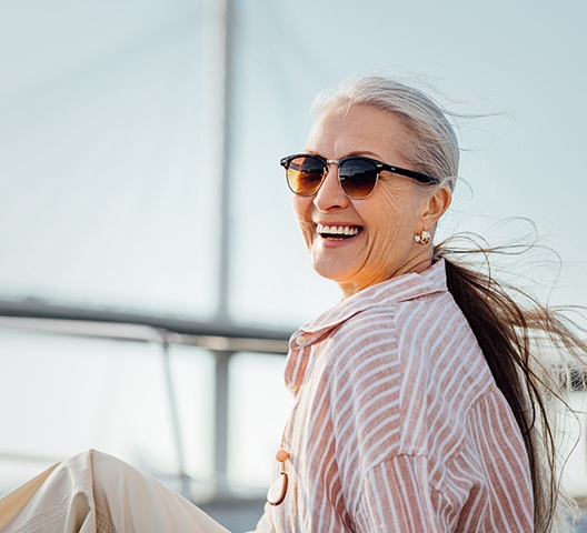 Woman with sunglasses smiling on boat