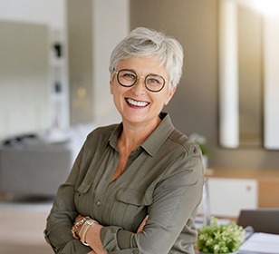 Woman with black glasses smiling at home