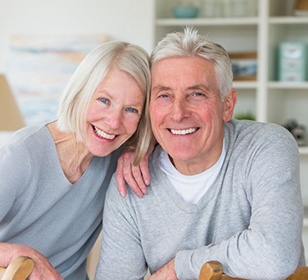 senior man and woman in matching gray sweaters 