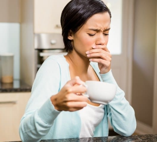 Woman in need of emergency dentistry covering her mouth