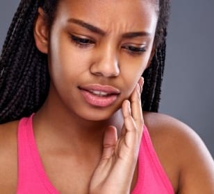 Woman with toothache holding cheek