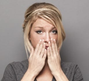 Woman with lost filling covering her mouth