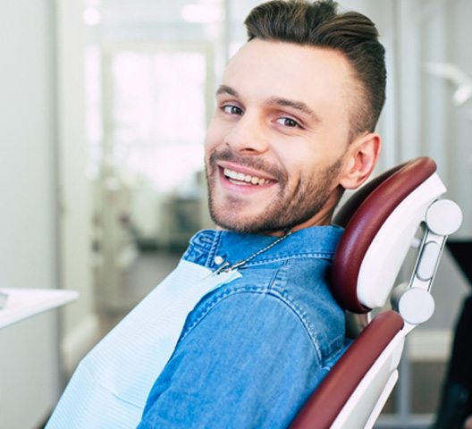 A smiling man sitting in a dentist’s chair
