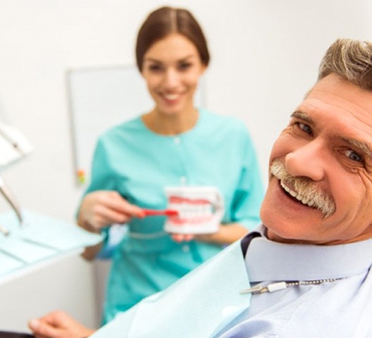 senior man at a consultation for implant dentures