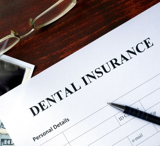 dental insurance paperwork next to dental X-rays