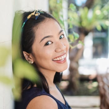 Woman with gorgeous smile leaning against a wall