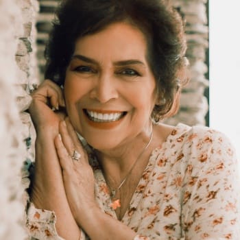 Older woman smiling with a silver necklace