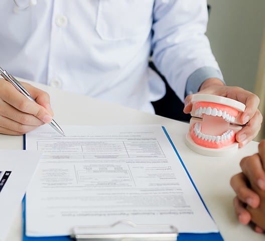 Dentist and patient reviewing dental insurance forms