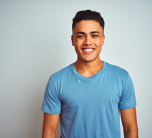 smiling young adult in a blue shirt