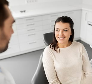 Woman smiling at dentist during initial consultation
