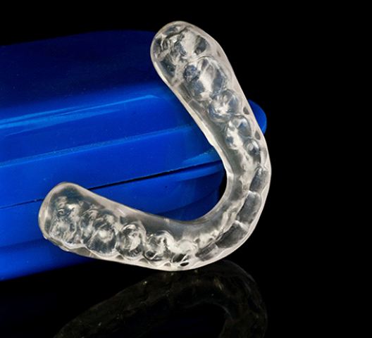 Close up of clear retainer with blue case