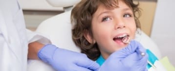 Young boy receiving children's dentistry treatment