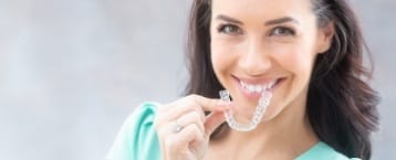 Woman placing Invisalign tray