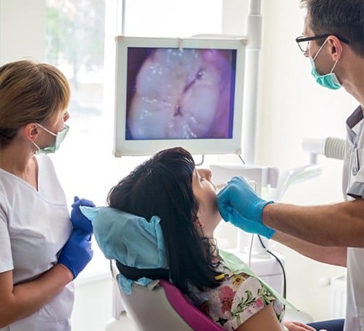 Dentist looking at intraoral images of patient's smile