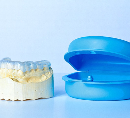 Model of lower arch with clear retainer and blue case