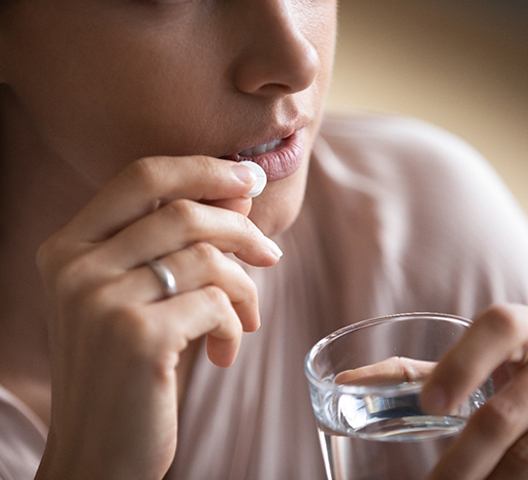 Woman taking pain reliever to cope with toothache