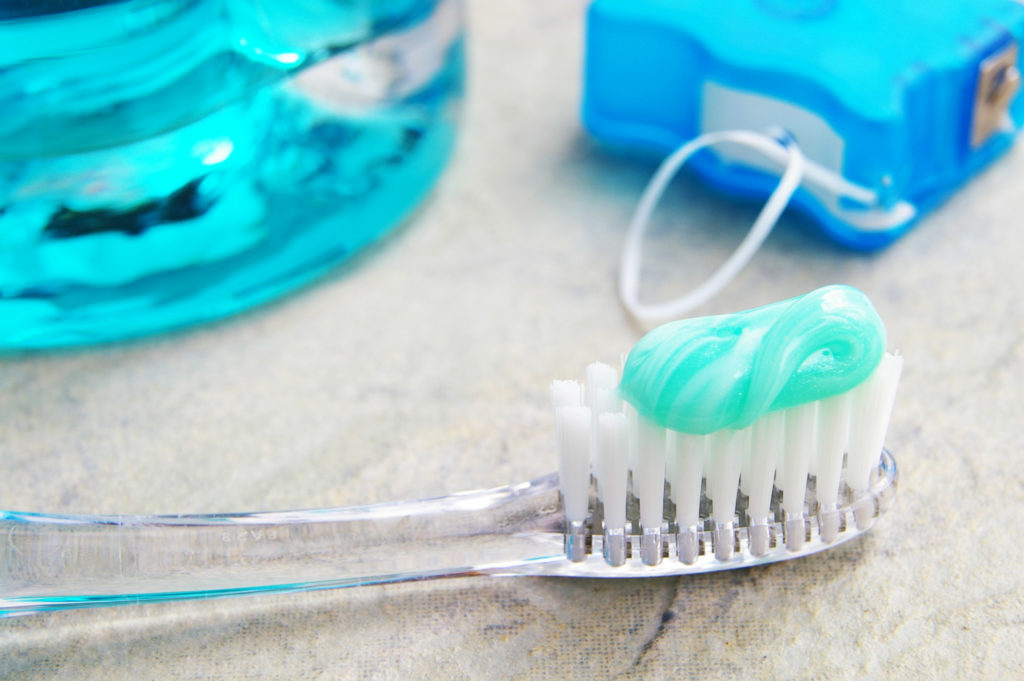 Close up of toothbrush, floss, and mouthwash