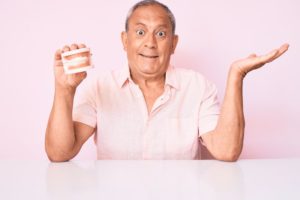 mature man holding dentures