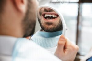 Man smiling after replacing metal filling with modern version