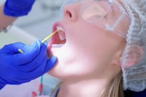 Dentist administering fluoride treatment.